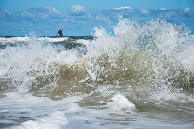 Man surfing in sea against sky