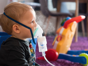 Side view of cute baby boy taking steam at home