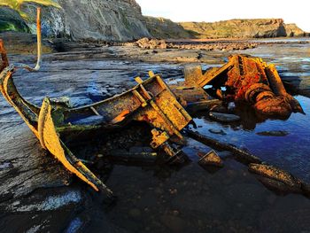 Abandoned boat moored on beach