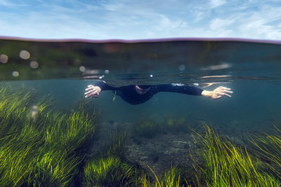 Mid adult man diving in to sea against sky