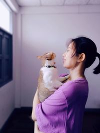 Side view of young woman with teddy bear