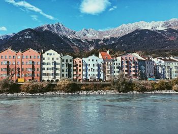 Buildings by mountains against sky