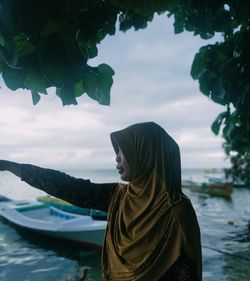 Woman looking at sea against sky