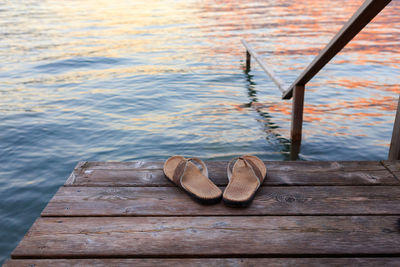 High angle view of flip flops on pier over lake