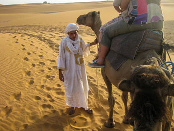 People on sand dune in desert