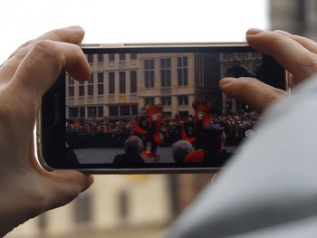 Close-up of man photographing against sky