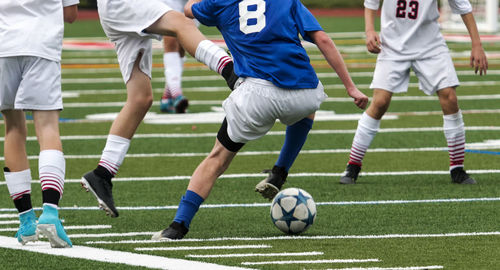 Group of people playing soccer on field