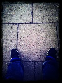 Low section of man standing on tiled floor