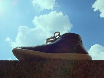 Low angle view of shoes against sky