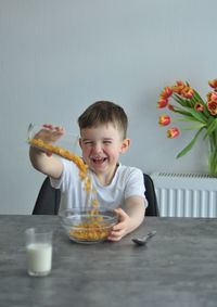 Portrait of boy eating food on table