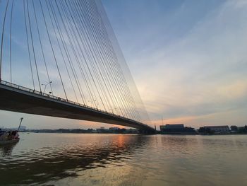 Bridge over river against sky during sunset