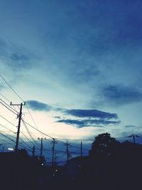 Low angle view of electricity pylon against blue sky