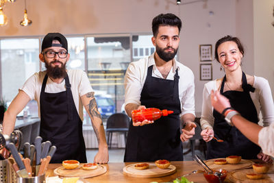 Portrait of smiling friends having food at home