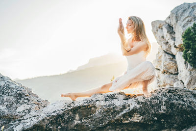 Young woman sitting on rock