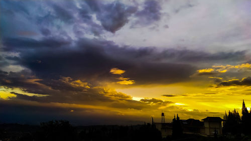 Silhouette buildings against sky during sunset