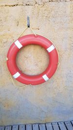 Close-up of red bell hanging against wall