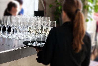 Rear view of waitress serving drinks in restaurant