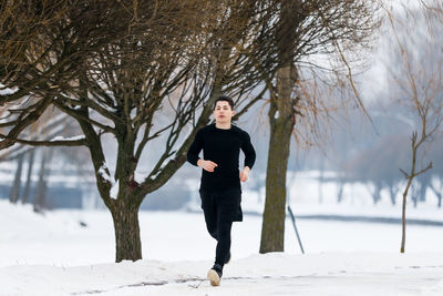 Full length of man standing on snow covered field