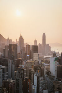 Modern buildings in city against sky during sunset