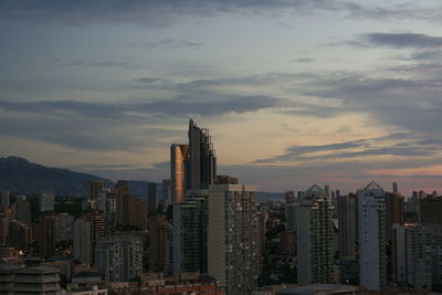 View of cityscape against cloudy sky during sunset