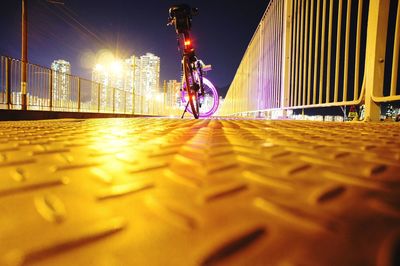 Surface level of bicycle against illuminated city at night