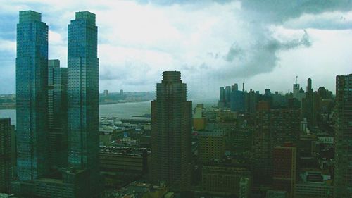 View of cityscape against cloudy sky