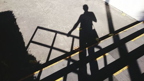 High angle view of silhouette man standing on shadow