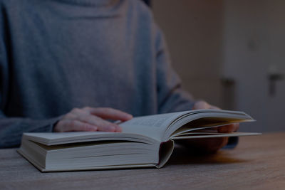 Midsection of woman reading book