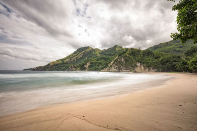 Scenic view of beach and mountains against sky