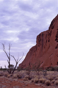 Uluru against cloudy sky