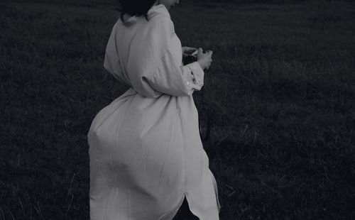 Rear view of woman standing on field