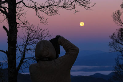 Rear view of person against sky during sunset