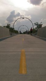 Empty road against cloudy sky