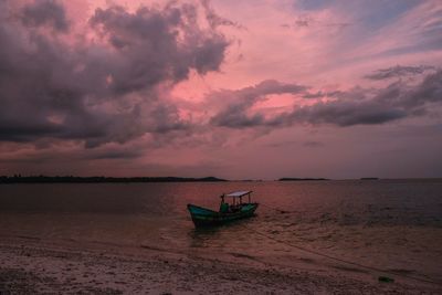 Boat on sea against sky during sunset