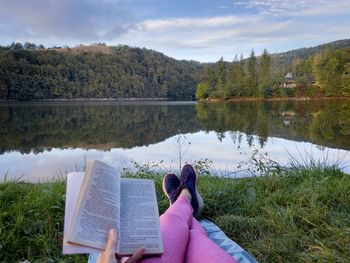 Low section of woman sitting on lake