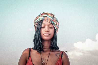 Portrait of young woman wearing hat against sky