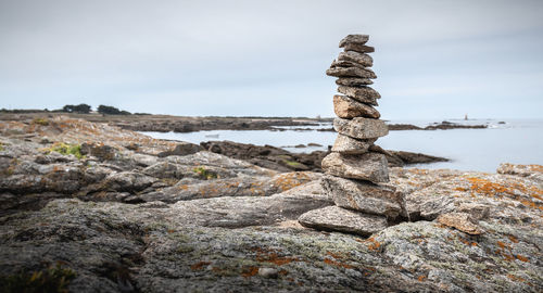 Stack of rocks on shore against sky