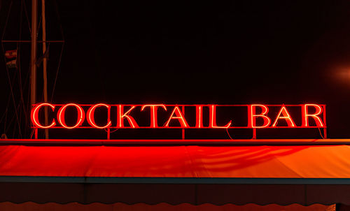 Red neon cocktail bar sign at night