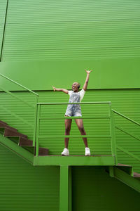 Full length of woman standing against wall