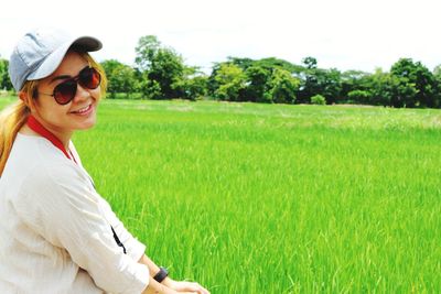 Portrait of smiling woman wearing sunglasses by rice field