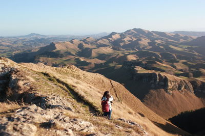 Rear view of man on mountain against sky