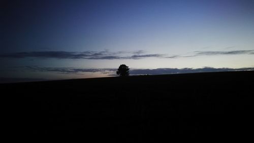 Silhouette of man on tree against sky