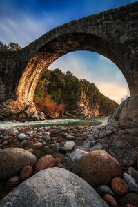 Arch bridge over river against sky