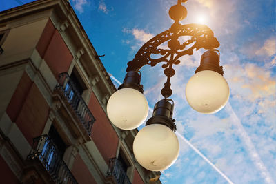 Low angle view of illuminated street light against sky