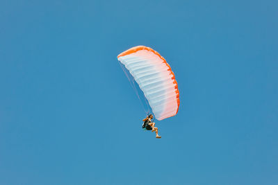 Young man paragliding during summer off cliffs in baja, mexico.