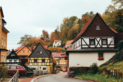 Houses by street in town against sky