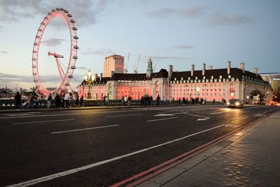 People on westminster bridge against millennium wheel during sunset