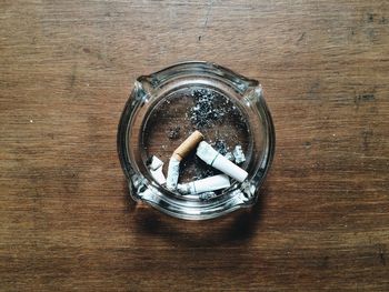 Directly above shot of cigarette buts in ashtray on table