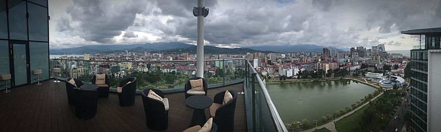 Panoramic view of city by lake against sky