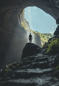 Silhouette man on rock against mountains